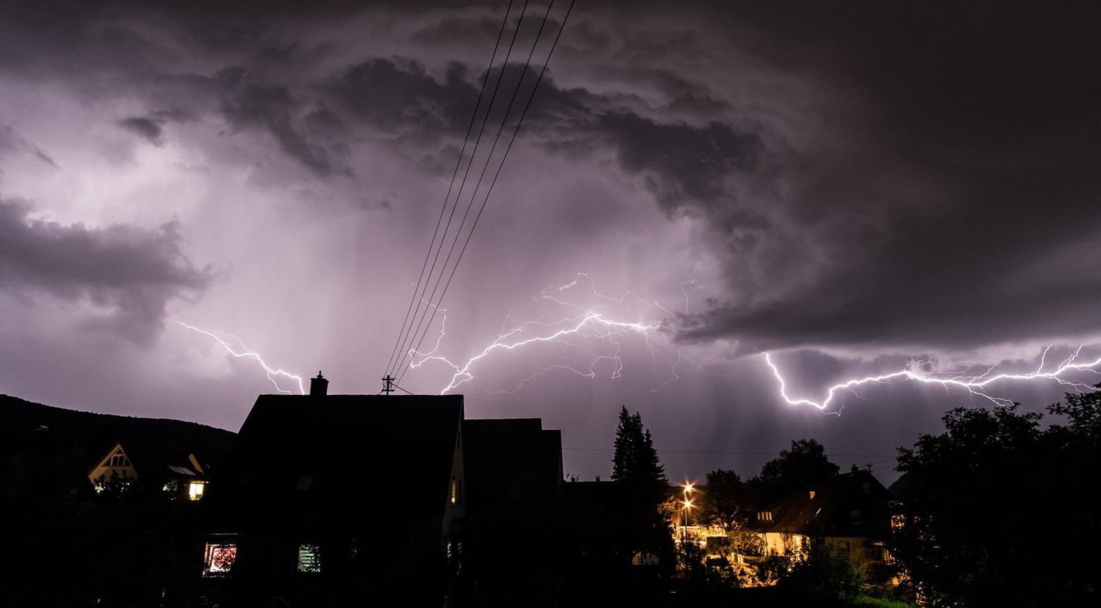 Orage et éclairs au-dessus d'un quartier résidentiel — le Powerwall se recharge avant la tempête